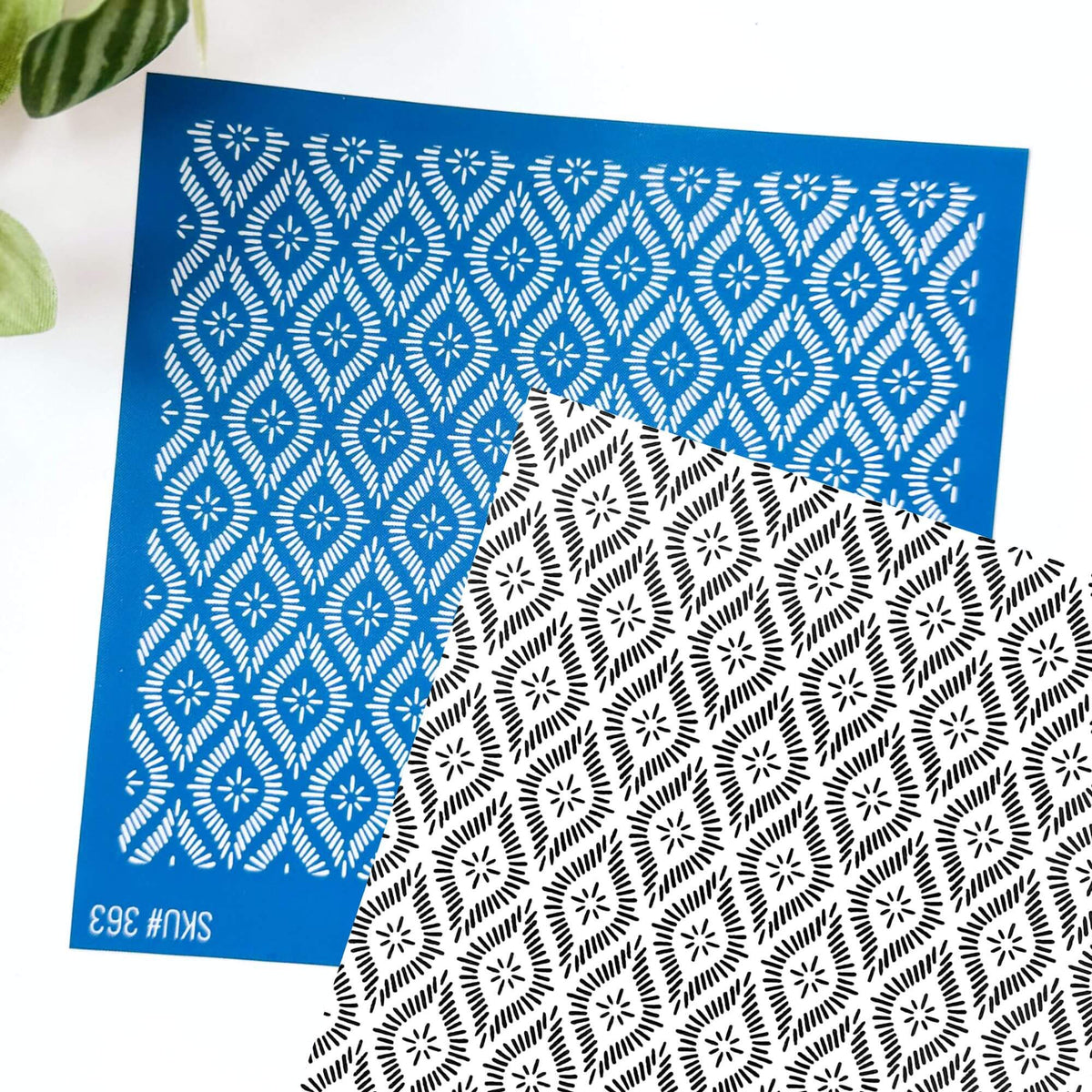 Diamond silkscreen stencil - ornate pattern. Black and white background shows the image transfer with the blue silkscreen laid over the top at an angle.