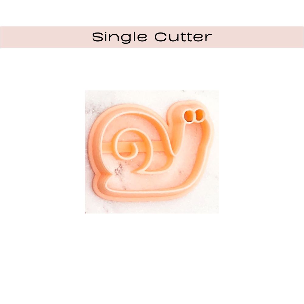 hand holding white snail shaped polymer clay cut out- snail in shell clay cutter - singlle cutter