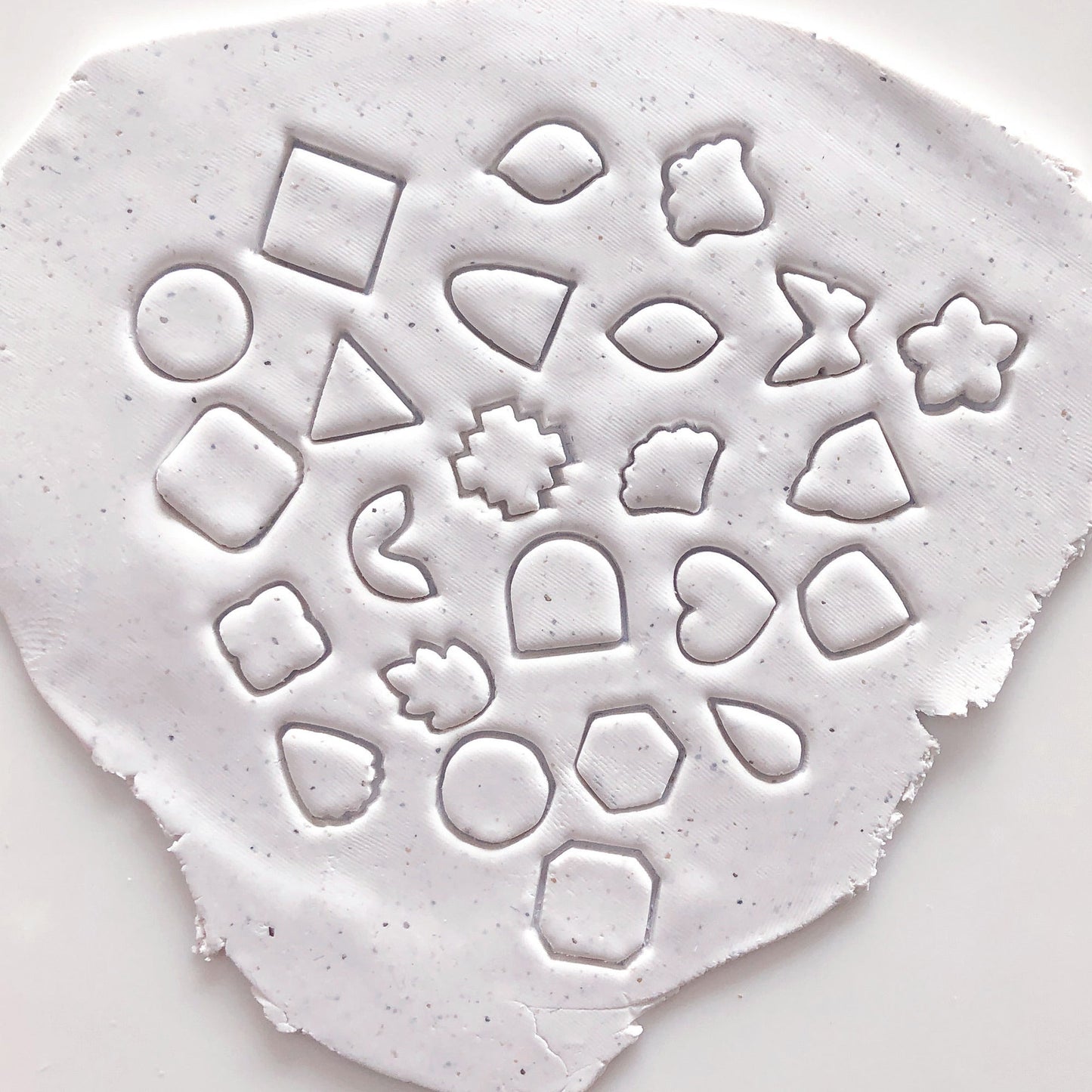 Mini polymer clay cutters - 10mm, set- choose any shape. This photo shows lots of mini cutters laid out on a pink and white background.