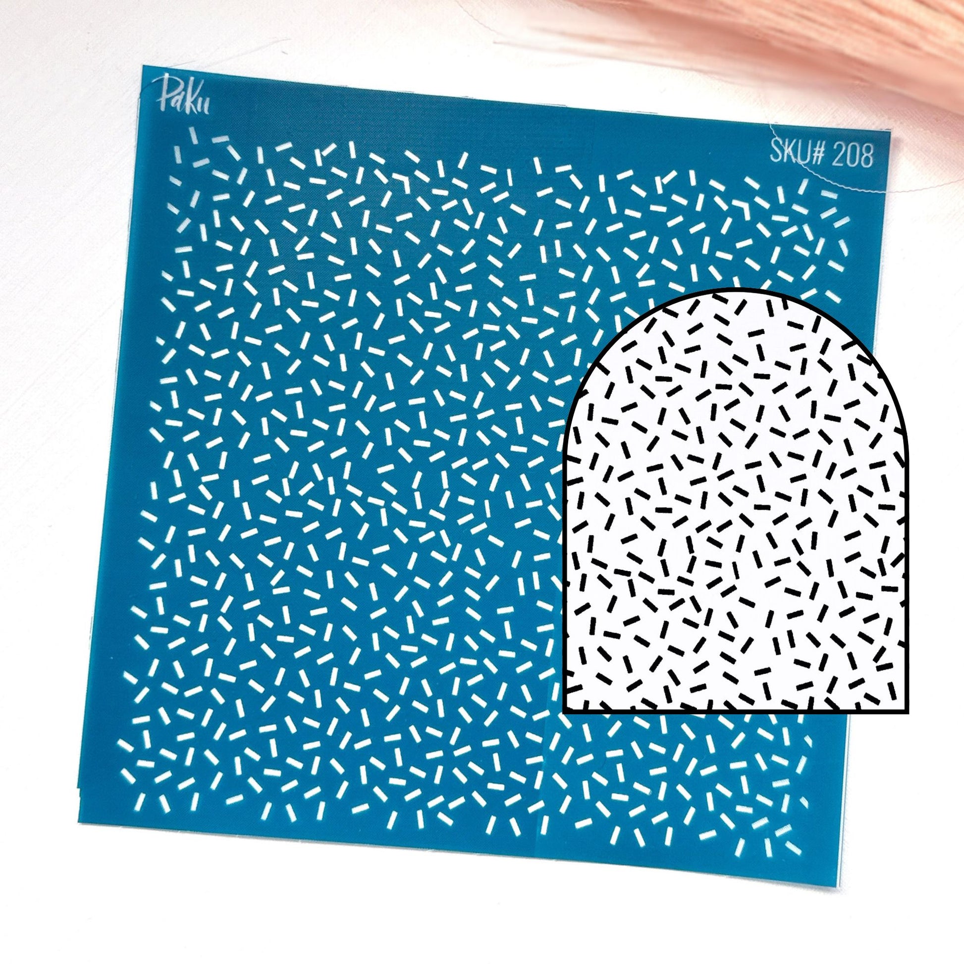A blue patterned silkscreen stencil with small white dash-like marks, shown on a white background with a smaller inset of a white arch-shaped area covered in black dash-like marks. Visible text includes 'Paku' and 'SKU# 208'.