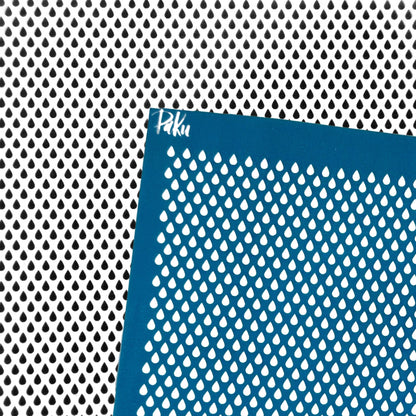 A blue silkscreen stencil sheet with a repeating teardrop-shaped cutout pattern, shown against a matching black-and-white perforated metal background. The brand name 'Paku' is printed in white near the top-left corner of the stencil.