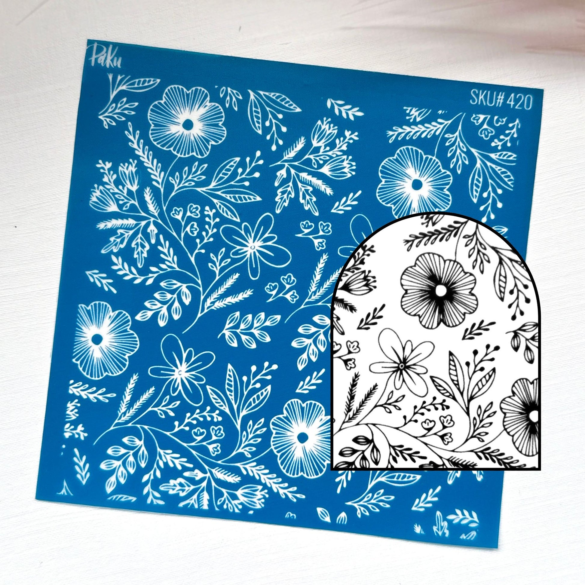 A blue rectangular sheet with white floral line art and the text 'Sku#420' is shown on a white background, alongside a black-and-white arched sample piece displaying the same floral pattern.