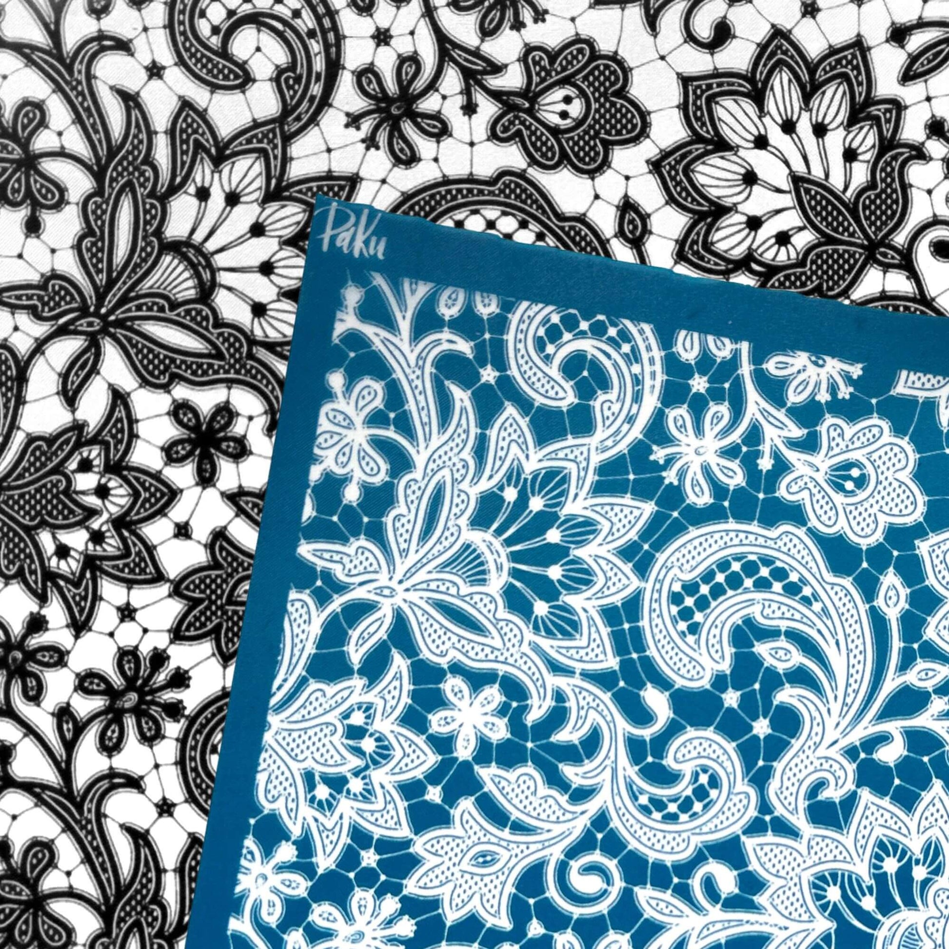 A blue and white lace silkscreen stencil sheet with a floral and paisley pattern, shown overlapping a black and white lace sheet. The brand name 'Paku' is visible in white script on the blue border.lkscreen 