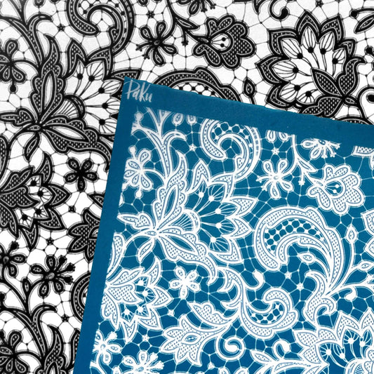 A blue and white lace silkscreen stencil sheet with a floral and paisley pattern, shown overlapping a black and white lace sheet. The brand name 'Paku' is visible in white script on the blue border.lkscreen 