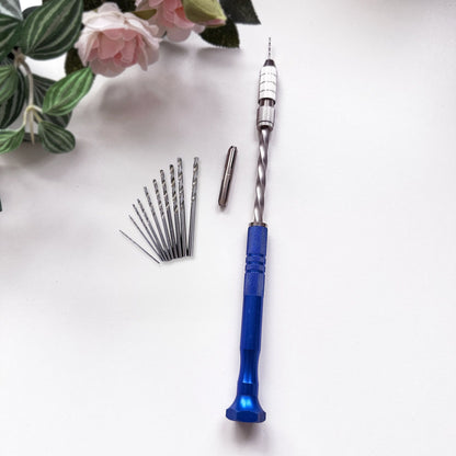 Blue semi-automatic push hand drill with drill bits for crafts on a white surface