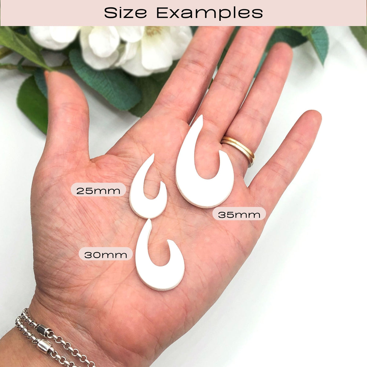 A hand holding three white droop hoop clay cut outs, with overlaid size labels reading 25mm, 30mm, and 35mm under a header that says Size Examples.