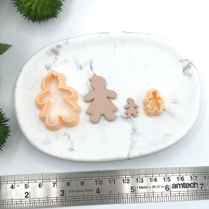 Gingerbread girl clay cookie cutter - polymer clay cut outs with the peach clay cutter sat on a marble white tray