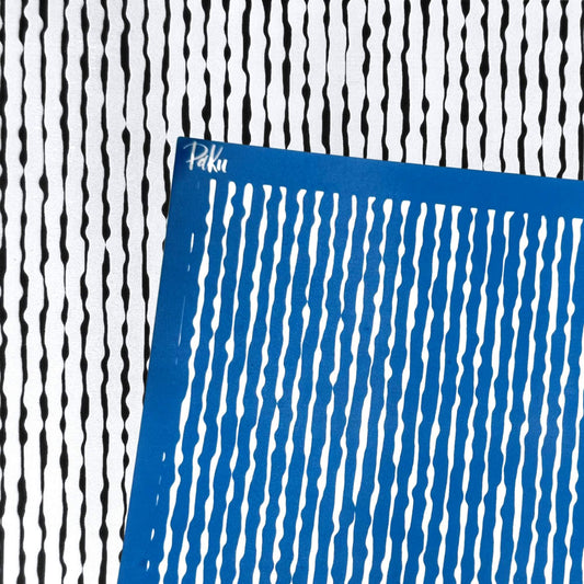 A blue square silkscreen stencil with vertical wavy organic lines, placed diagonally over a black and white striped patterned background. The brand name 'Paku' is visible in white script on the top-left corner of the blue sheet.