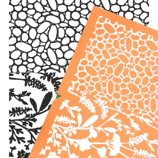 River rock silkscreen stencil. Surface paint screen for polymer clay - picture shows the orange silkscreen with wildflowers and pebbles overlaying a black & white image transfer of the design.