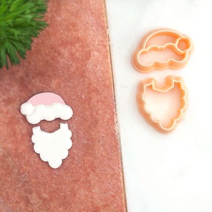 A Santa cut out and matching cookie cutters shown on a split terracotta and white background, with a small cutout Santa face piece on the left.