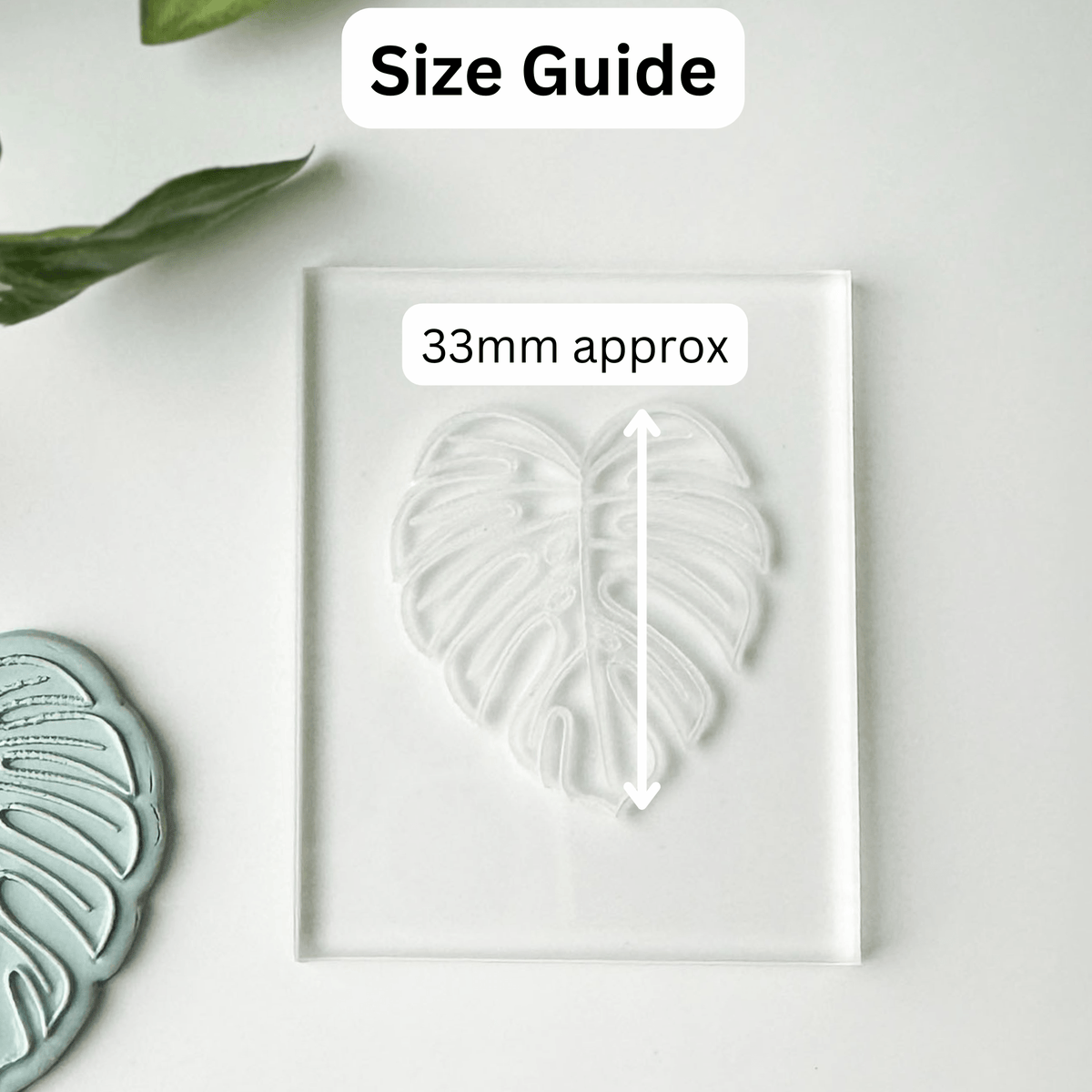 A clear acrylic block with a leaf-shaped impression or mold, shown on a white background with a 'Size Guide' label and '33mm approx' measurement callout. A partial matching leaf-shaped piece appears at the lower left.