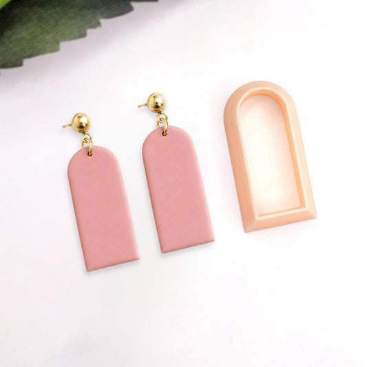 Polymer clay Pink earrings with gold accents on a white background. With the cutter next to it.