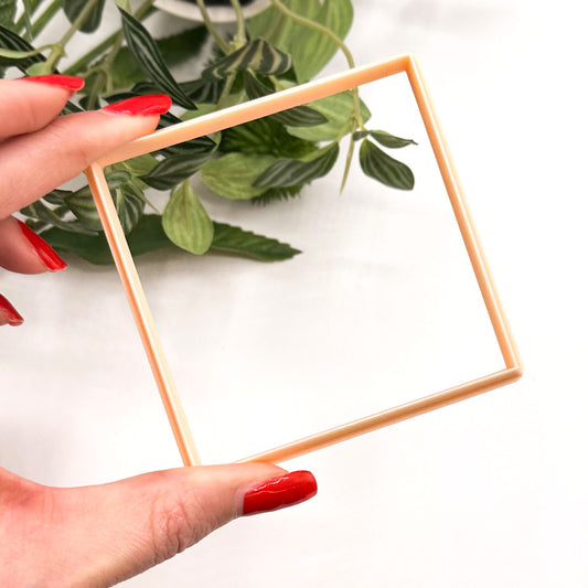 Large square clay cutter for larger clay crafts like pottery clocks, coasters, tricket plates, jewellery trays etc. The cutter is being held in hand tilted with leafs on a white background