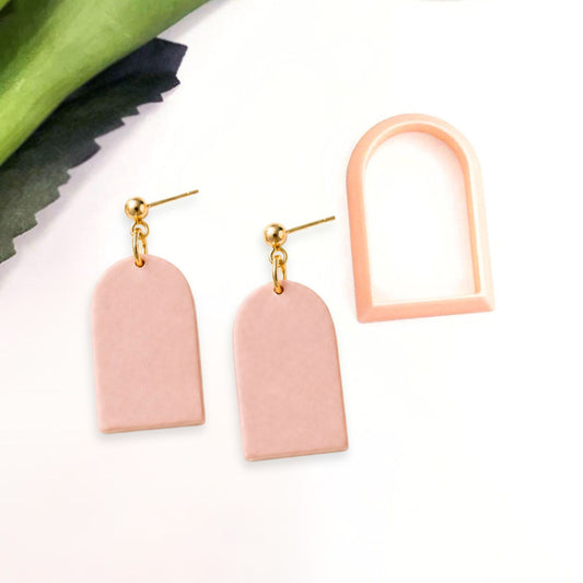 Polymer clay Pink arch earrings with gold accents made with the arch clay cutter on a white background