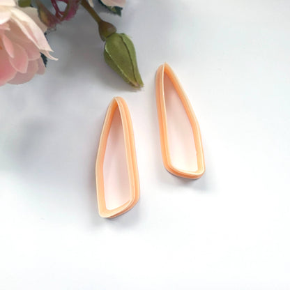 Clayboutique organic scalene dagger peach clay cutter mirror set of two on a white back ground with flowers in the corner