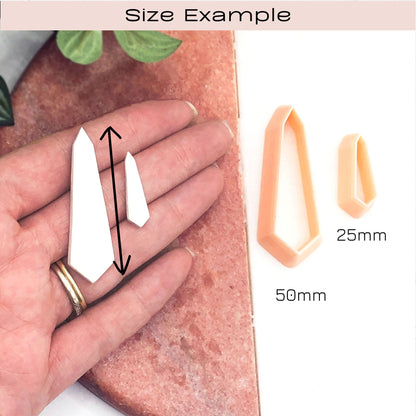 Size example graphic showing two white pointed crystal-shaped pieces on a hand for scale, alongside two peach-colored clay cutters labeled 25mm and 50mm, under the heading 'Size Example'.