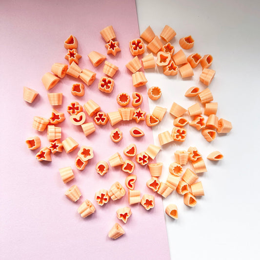 Mini polymer clay cutters - 10mm, set- choose any shape. This photo shows lots of mini cutters laid out on a pink and white background.