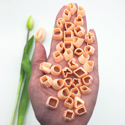 Mini polymer clay cutters - 10mm, set- choose any shape. This photo shows lots of mini cutters laid out on a pink and white background.