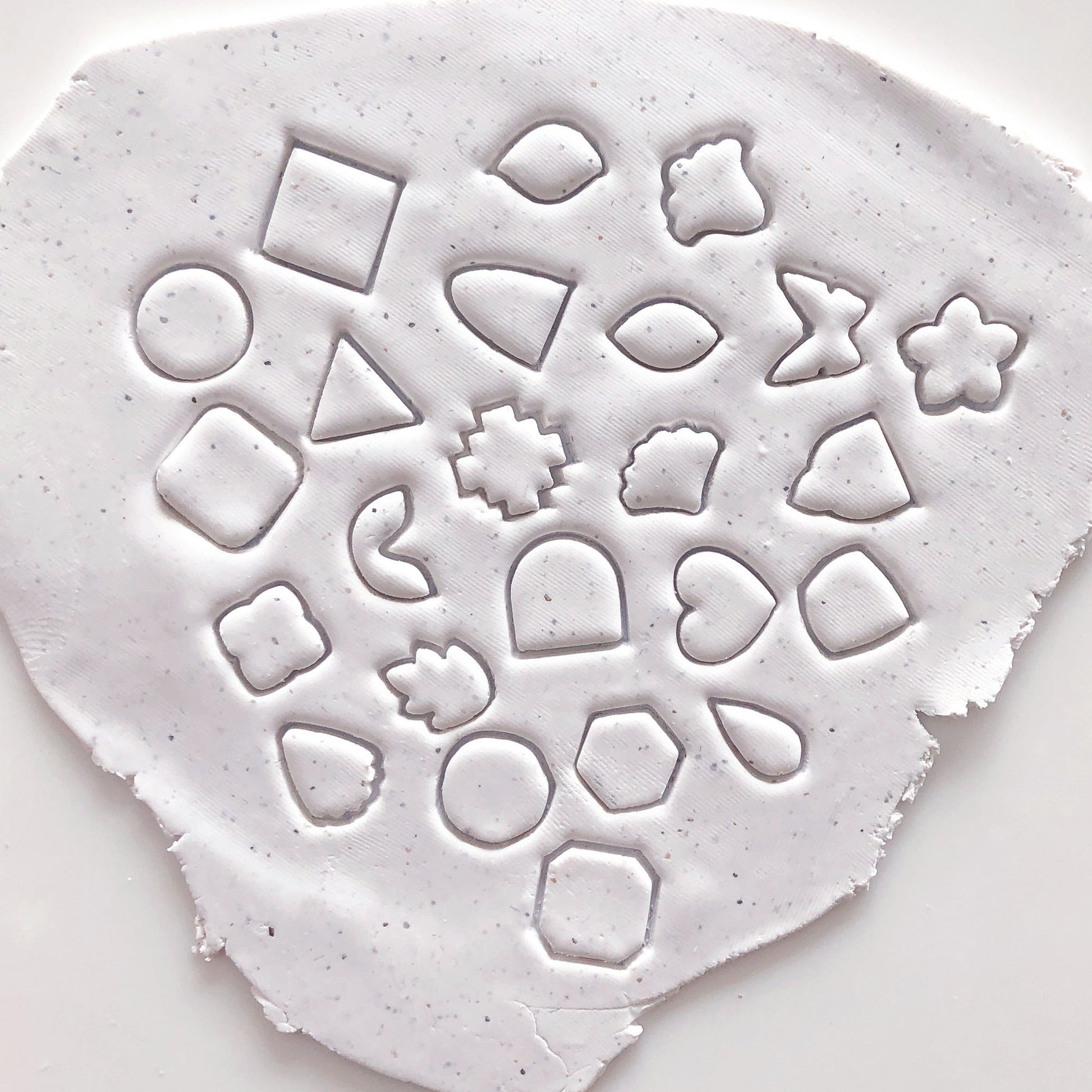 Mini polymer clay cutters - 10mm, set- choose any shape. This photo shows lots of mini cutters laid out on a pink and white background.