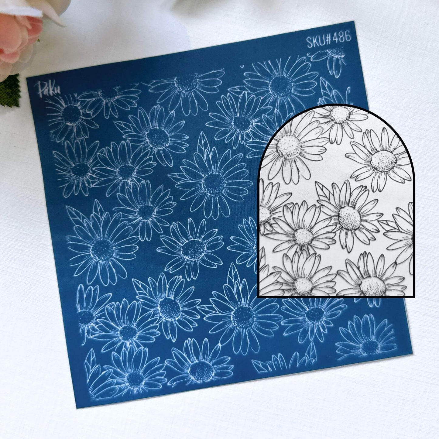 Blue silkscreen Paku stencil with white floral daisy patterns on a white background. For use with polymer clay and cake making.