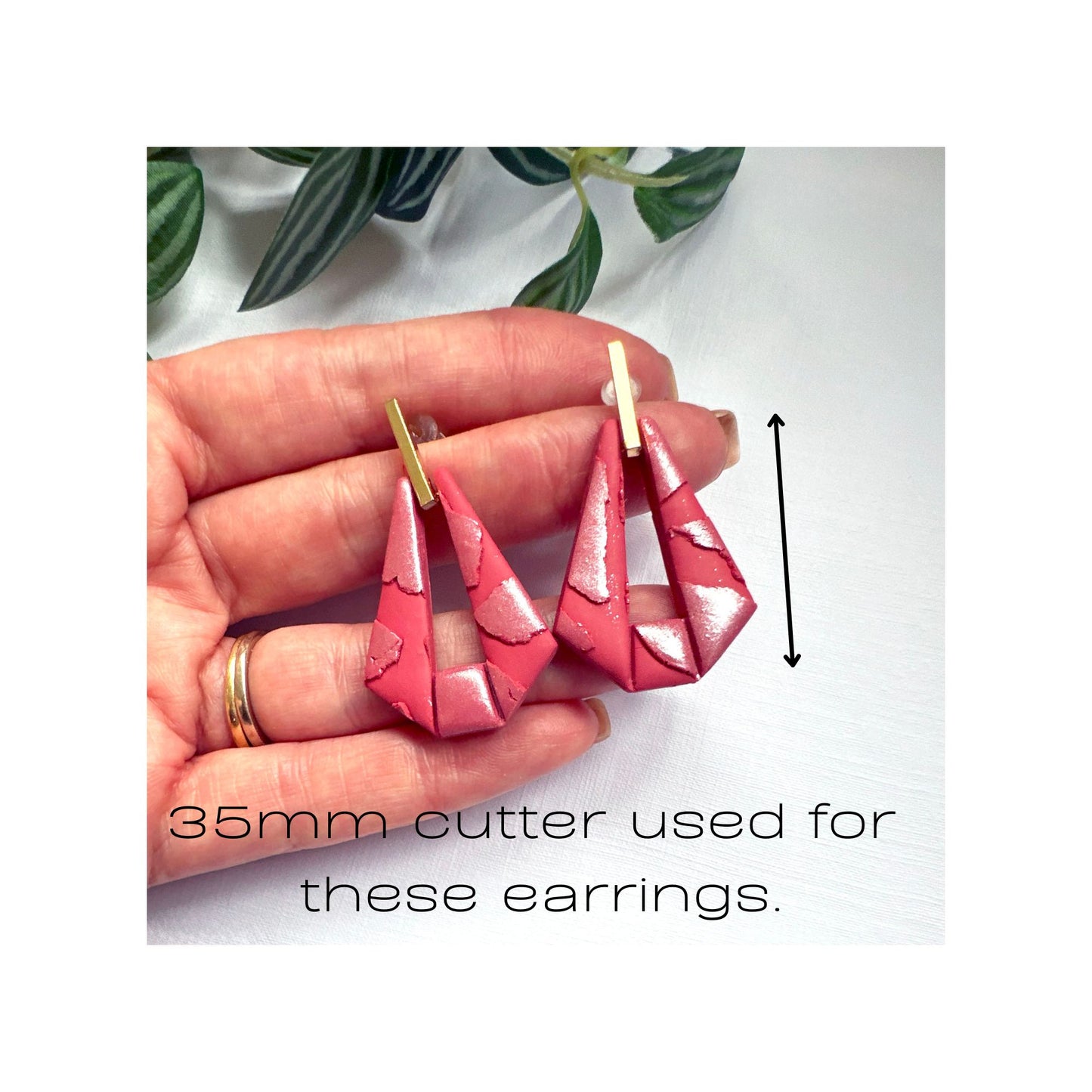 A hand holds a pair of handmade pink geometric earrings with gold-tone posts. The image includes text stating '35mm cutter used for these earrings' and a vertical measurement arrow indicating the size of the earrings.