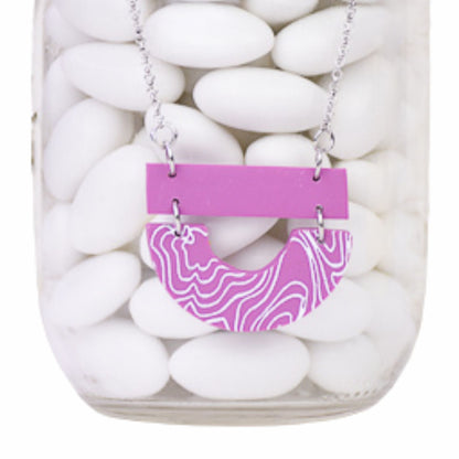 Mauve polymer clay Necklace with a pink and white patterned pendant on a white stone background