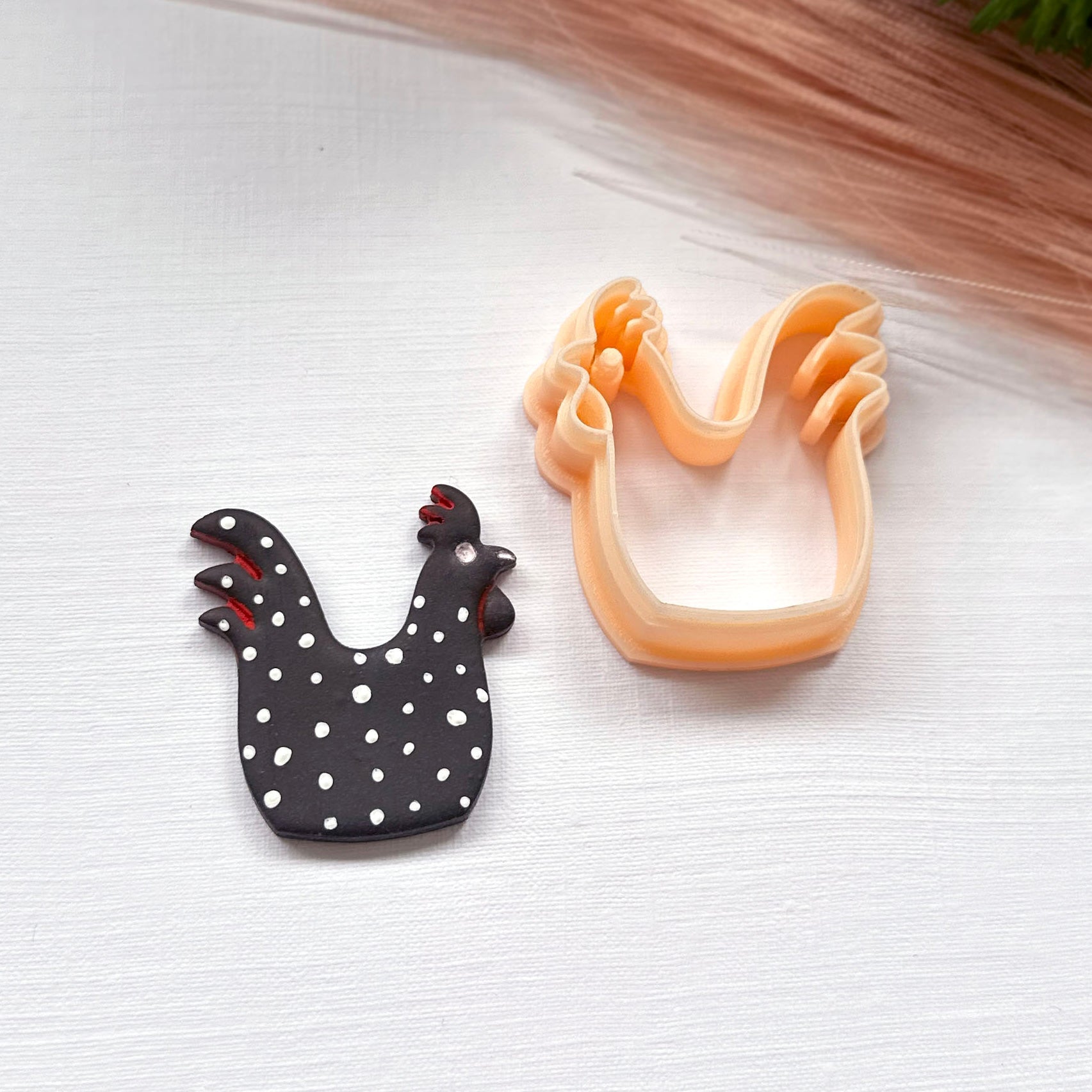 Rooster clay cutter for polymer clay crafts and jewellery making. This rooster is made using the 35mm clay cutter, it is black polymer clay and has white spots painted.
