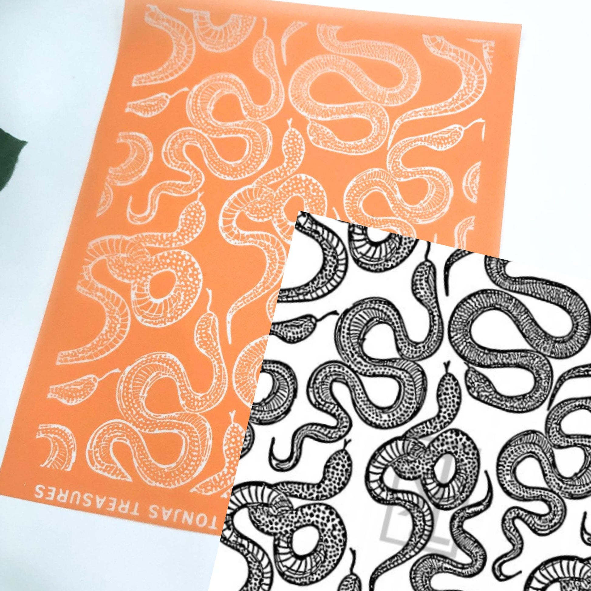 Orange silkscreen stencil with a repeating snake design. The one in black ink on white is the image reversed The orange sheet shows the brand name 'TONAS TREASURES' along the bottom edge.