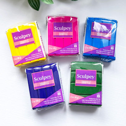 Five packages of Sculpey Souffle clay in different colors on a white background.