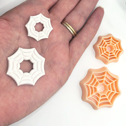 spider web clay cutters in a 25 and 35mm and polymer clay spiderweb cut outs made using the cutters on a hand