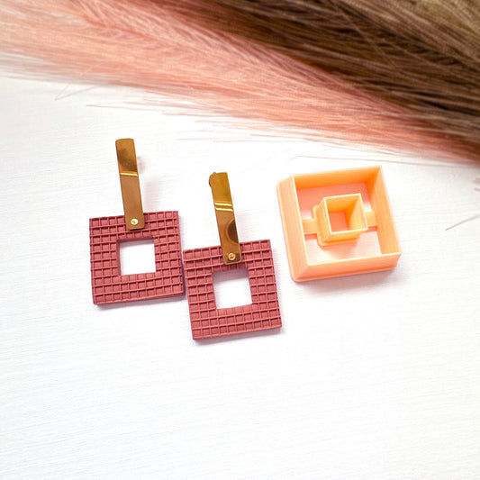 Square donut clay cutter for art clay jewellery and earring making. The picture shows the square clay cutter beside a pair of brick coloured square earrings made from polymer clay