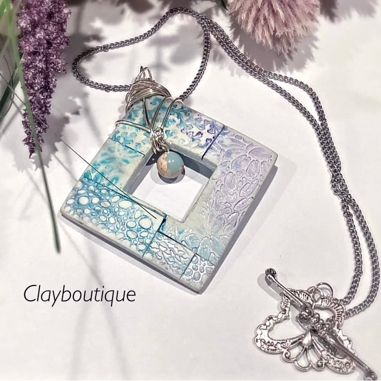 Necklace with a square pendant and chain on a white background, featuring the brand 'Clayboutique'. Made with our square donut clay cutter